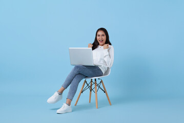 Young woman asian happy smiling celebrate. While her using laptop sitting on white chair isolated...