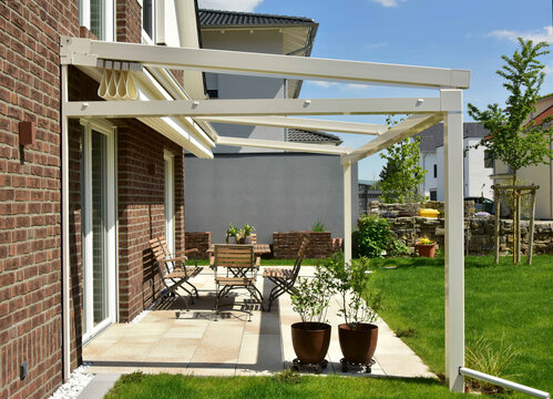 Sonnendach / Pergola als Sonnenschutz auf der Terrasse eines neu gebauten Wohnhauses