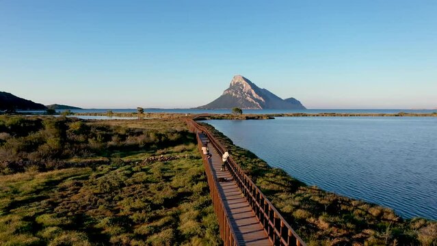 Gro&szlig;er Holzsteg &uuml;ber einem See bei Porto Taverna direkt am Meer. Im Hintergrund sieht man die Insel Tavolara. Sardegna Drone 4