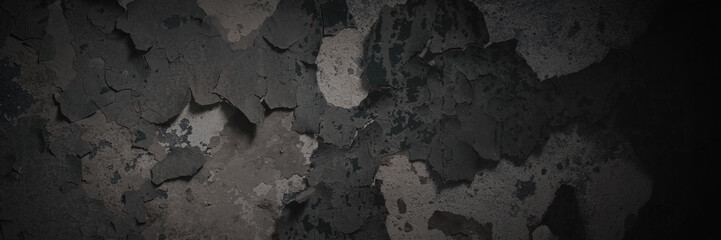Dark wide panoramic background. Peeling paint on a concrete wall. Dark grunge texture of old cracked flaking paint. Weathered rough painted surface. Patterns of cracks. Darkness background for design.