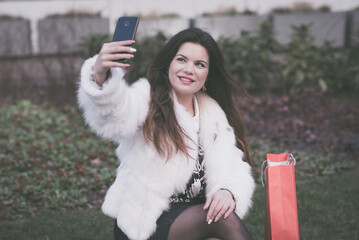 Elegant woman taking selfie after shopping