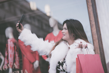 Elegant woman taking selfie after shopping
