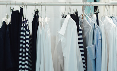 Choice of fashion clothes of different colors on  hangers in a retail shop. Reduce Reuse Recycle concept. Horizontal photo