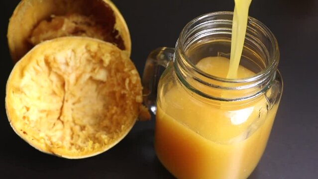 Juice of Bael also called as stone apple pouring into .Selective Focus