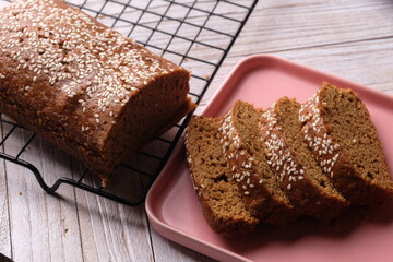 closeup of sesame-studded palm sugar bread slices on cooling rack. Indonesian traditional bread. Roti Ganjel Rel.