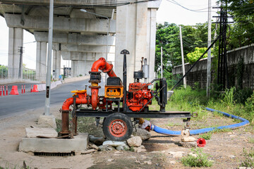 Mobile water pump is being pumped from the flooded area into the drain.