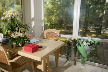 Small business. Flower shop interior. Floral design studio, decorations and arrangements and gifts. Flowers delivery service and sale of houseplants in pots, wooden showcase, nobody.