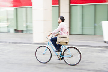 Young man on his commute to work using an eco friendly bicycle