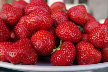 Un tas de fraises fraiches dans une assiette blanche 