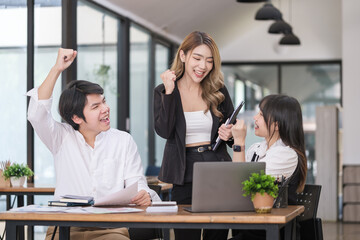 Excited young businesspeople celebrating start up business victory or success in office. Teamwork, collaboration concept.