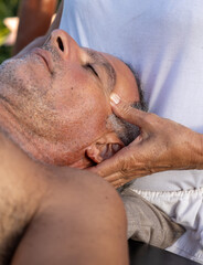 Naklejka premium Massage session at a resort. Masseur and his patient taking massage outdoors.