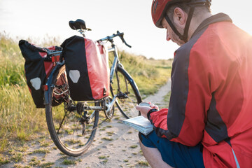 Touring cyclist using compass on map.
