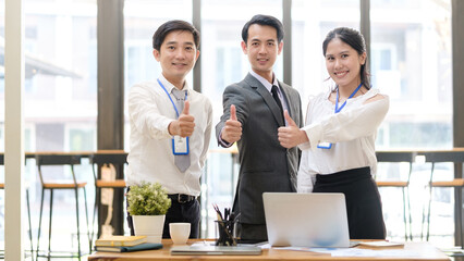 Excited young businesspeople celebrating start up business victory or success in office. Teamwork, collaboration concept.