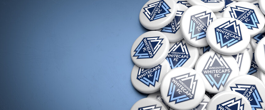 Logos of the American Soccer Team Vancouver Whitecaps FC (MLS Major League Soccer) on a heap on a table.