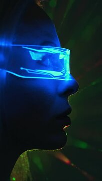 The woman in futuristic glasses on laser rays background. slow motion