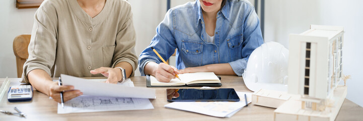 Engineering construction concept, Two female engineers is discussing construction and taking notes