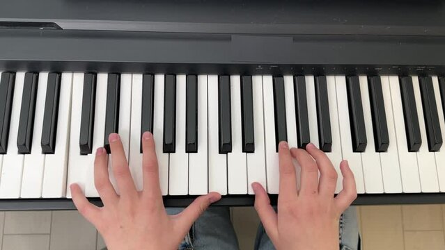 a little girl playing the piano at home, a girl playing a musical instrument, the hands of a child playing the piano close-up