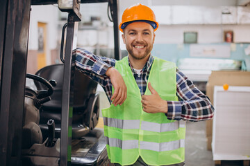 Man working at warehouse and driving forklift - obrazy, fototapety, plakaty