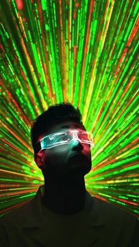 The handsome man in modern glasses stands on a color rays background. slow motion