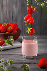 Strawberry smoothie or milkshake in jar on gray wooden background, healthy food for breakfast