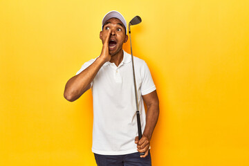 African American man golfer, yellow studio backdrop, shouting and holding palm near opened mouth.