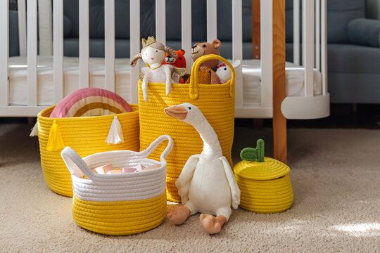 Yellow Toy Storage Baskets in the children's room. Cloth stylish Baskets with toys. Organizing and Storage Ideas in nursery. Clean up toys and  reduce the clutter.