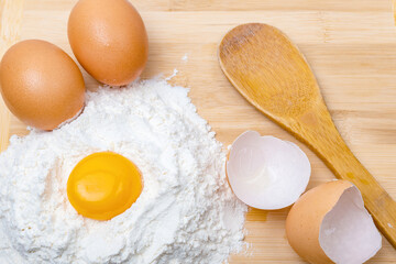 egg yolk, flour, two eggs and a wooden spoon