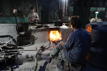 Preparing meals using a mud chula and wood fire