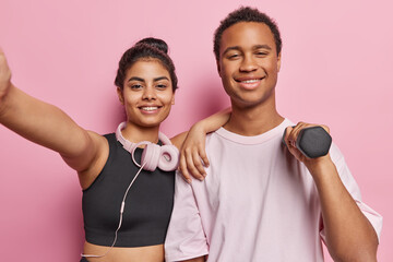 Couple of fitness enthusiasts man and woman showcase their dedication at sport center lift dumbbell...