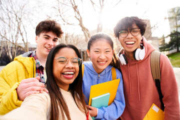 Group of multi-ethnic high school students taking a selfie outdoors at the university campus...