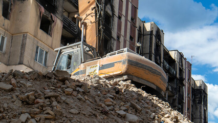 The process of demolition of the old dismantling of the building. The excavator breaks the house. Demolition of dilapidated housing. Construction digger demolishing a house for renovation.