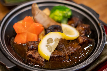 Diced meat steak served on plate with lemon, carrot and vegetable