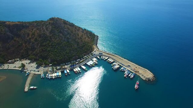 Aerial view of sea and clear turquoise waves with a small marina in Turkey