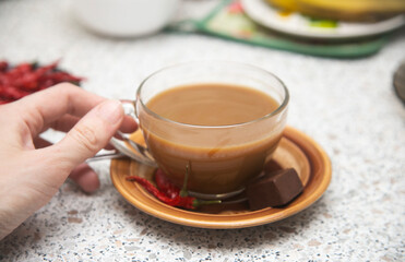 cup of coffee with chili pepper and womans hand