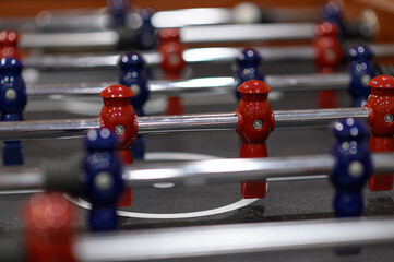 Close-up plastic players in table football in entertainment center. Soccer table with red and blue players.