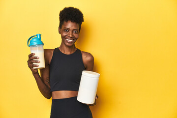 African woman in sportswear with protein powder and shake.