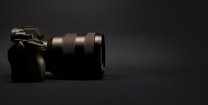 Photo camera on dark background. Side view. Copy space. Horizontal banner