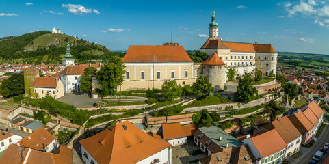 Aerial view of restored Baroque Mikulov castle in Southern Bohemia also called Nikolsburg with medieval towers surrounded by communist style houses - obrazy, fototapety, plakaty