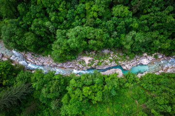 Soca river in Slovenia. Aerial drone top down view of emerald green river in forest