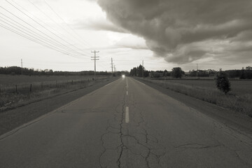 Incoming storm over a road and farmers field