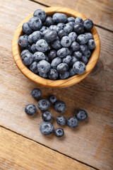 Freshly picked blueberries in a wooden bowl. Healthy food and nutrition concept.