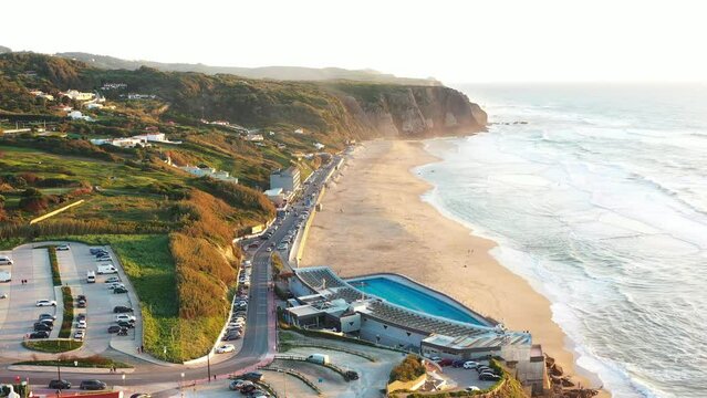 Sunset on the beach Praia Grande, Portugal. Beautiful sunset on the Portuguese beach Praia Grande, in Portugal. Beach of Praia Grande. View of Atlantic beach and big waves. Colares, Sintra, Portugal.