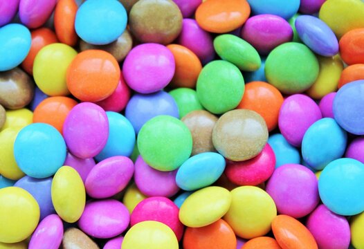Multi colored candy coated chocolate button sprinkle texture - marties, sprinkles