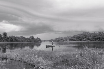 Fishing on a river with an oncoming storm