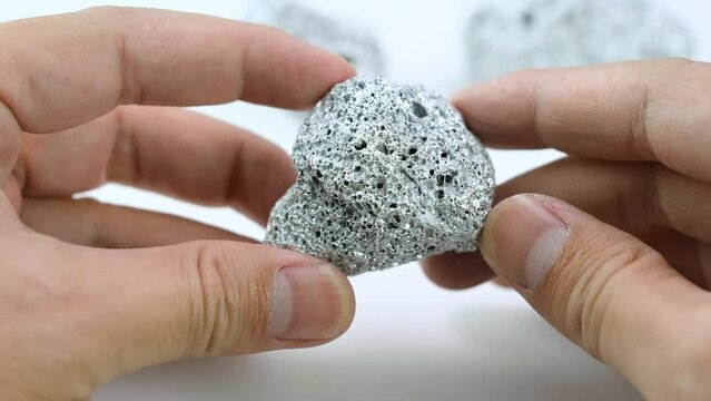 Geologists hold platinum or silver or rare minerals found in mines for inspection and consideration in the lab