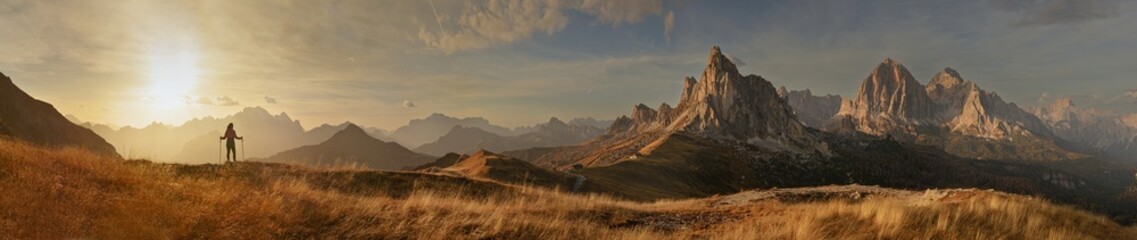 Great panorama of the Giau Pass with mountain Ra Gusela and a tourist at sunset. 