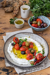 Popular middle eastern appetizer labneh  .Cream cheese dip with olive oil, Cherry tomatoes,cucumber, herbs and olives