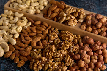 Assortment of goods from different dried delicious healthy nuts in the store. Healthy nut mix for a healthy snack in a pile on a gray table