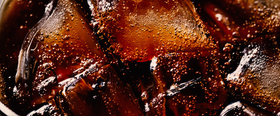 Cola with Ice. Close up of the ice cubes in cola water. Texture of carbonate drink with bubbles in...