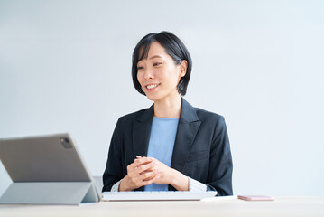 タブレットPCを使って、オンラインコミュニケーションをするビジネスウーマン